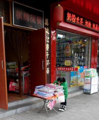 在街边货品上做作业的小盆友
